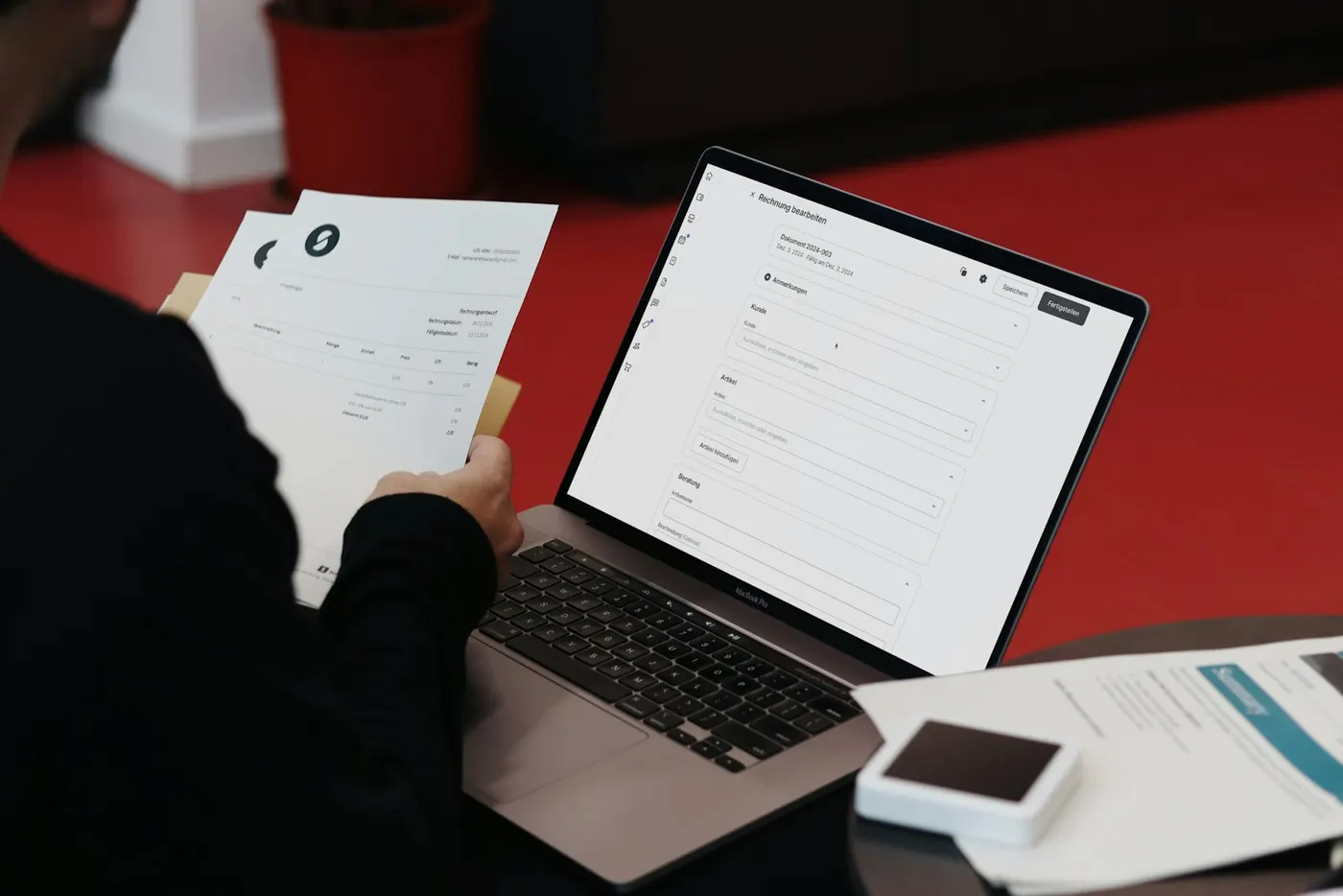 Papierstapel, Rechnungen und ein Laptop auf einem Schreibtisch, der Alltag eines Eigentümers